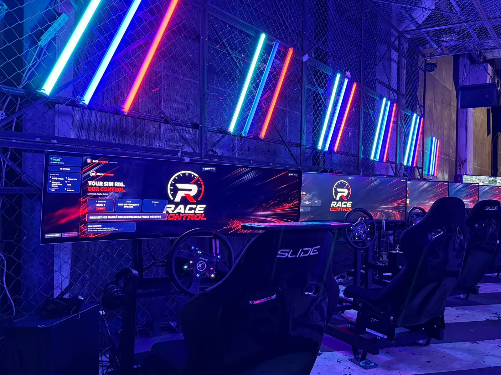 Five RaceControl-managed simulators lined up under neon at the Gdańsk festival stand